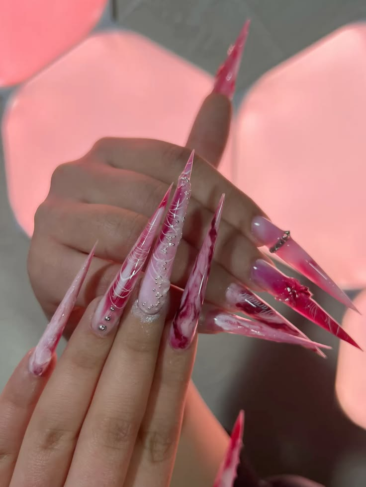 Dramatic stiletto nail art with pink marble swirls, fine thread lines, and silver beads at La Paige Nails