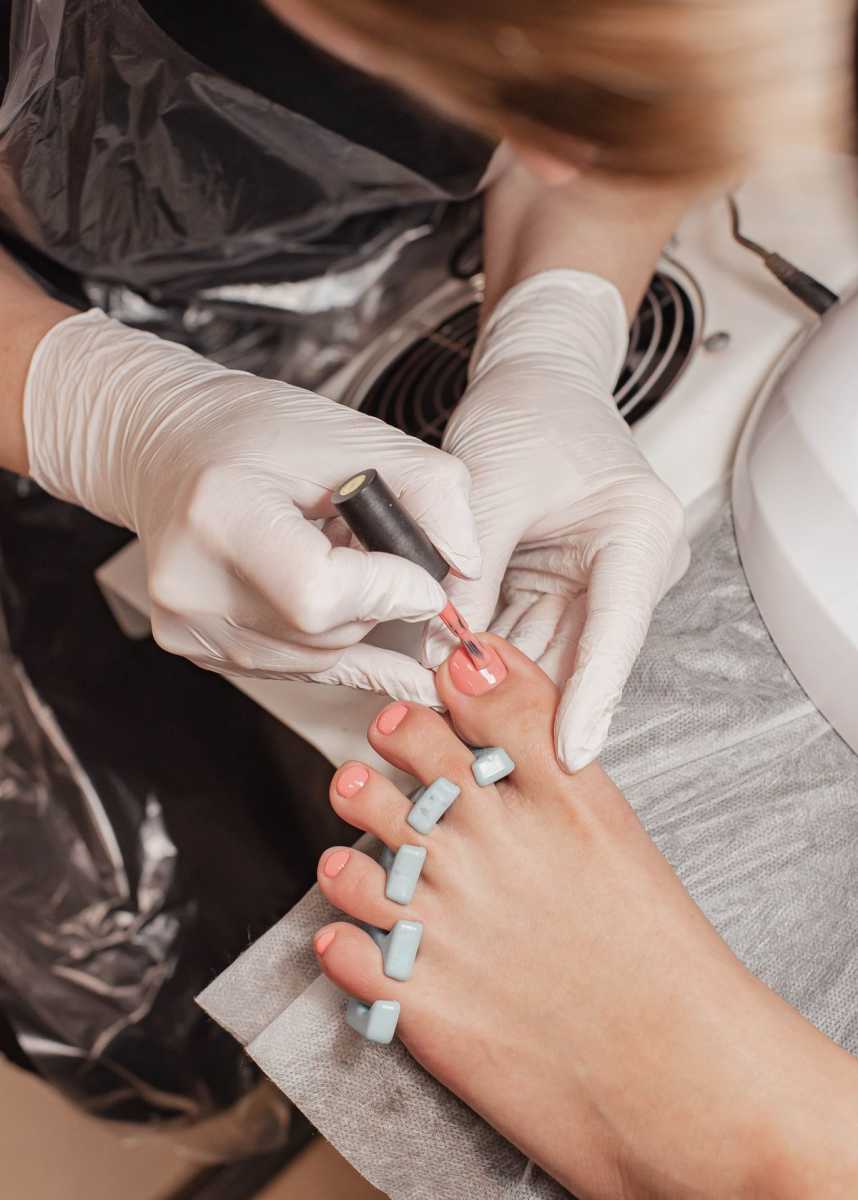 Hygienic manicure and pedicure CF Sherway Gardens foot care applying vibrant coral gel polish